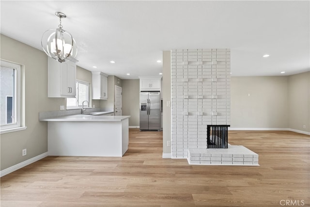 kitchen with stainless steel fridge with ice dispenser, kitchen peninsula, light hardwood / wood-style flooring, and white cabinets