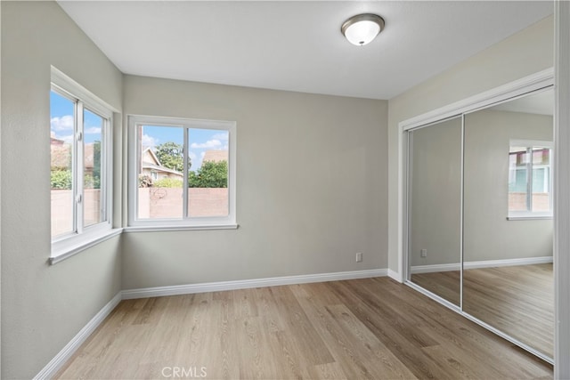 unfurnished bedroom with a closet and light hardwood / wood-style flooring