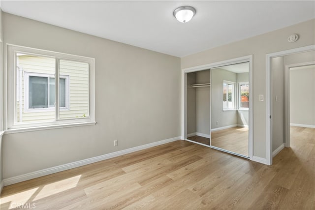 unfurnished bedroom with a closet and light hardwood / wood-style flooring