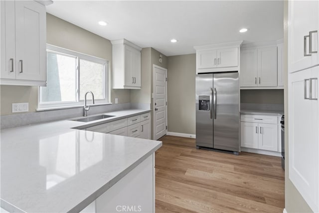 kitchen with sink, stainless steel fridge with ice dispenser, light hardwood / wood-style flooring, and white cabinets