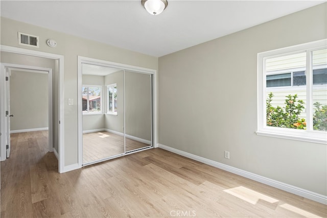 unfurnished bedroom with a closet and light hardwood / wood-style flooring