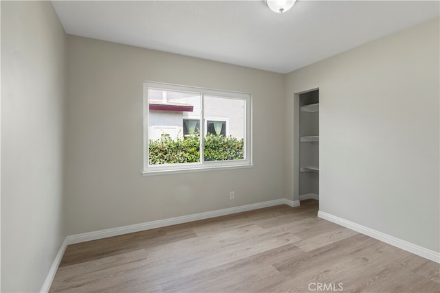 unfurnished bedroom with a closet and light hardwood / wood-style flooring