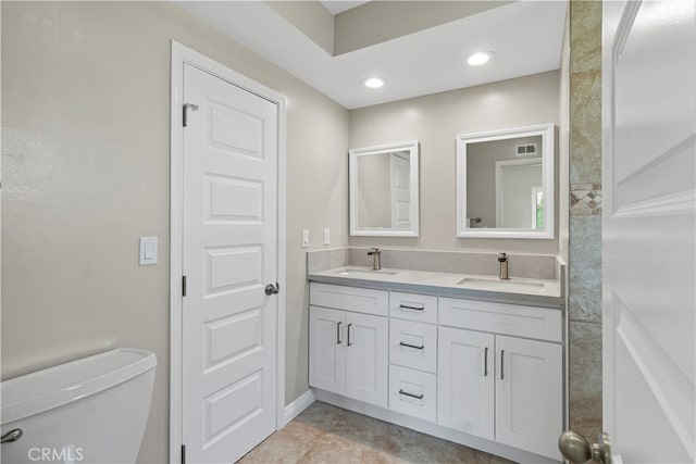 bathroom featuring toilet, vanity, and tile patterned flooring