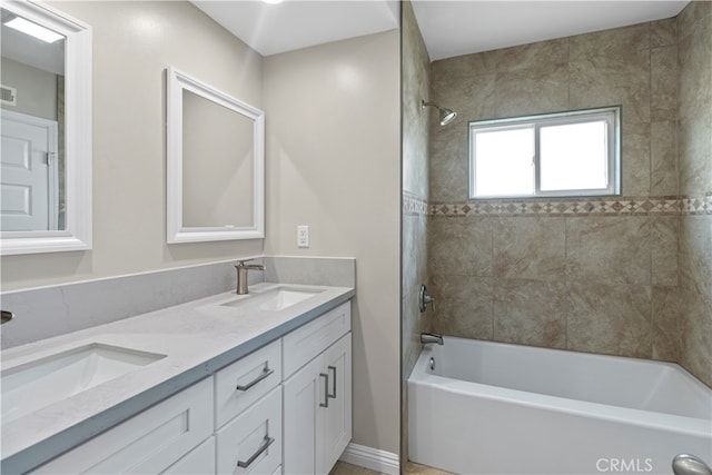 bathroom featuring tiled shower / bath and vanity