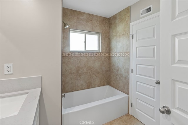 bathroom with vanity, tiled shower / bath combo, and tile patterned flooring