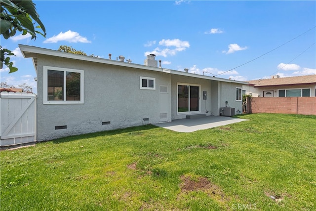 back of property with a patio area, central AC, and a lawn