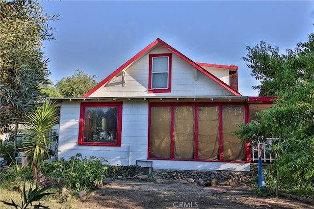 view of property exterior with a sunroom