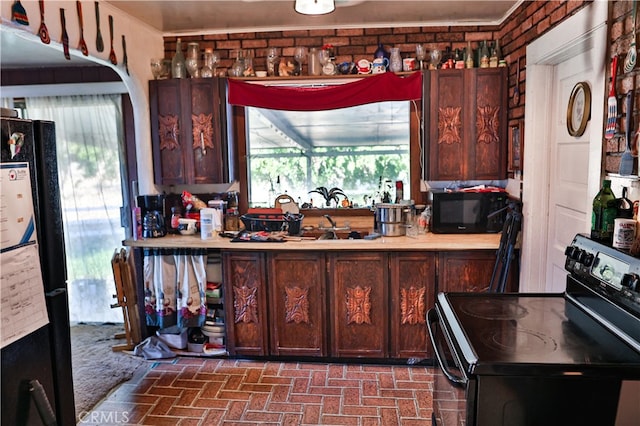 kitchen with black appliances and brick wall