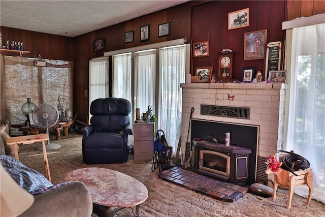 living area with a textured ceiling, a healthy amount of sunlight, and wooden walls