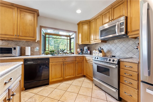 kitchen with backsplash, light tile patterned flooring, appliances with stainless steel finishes, and sink