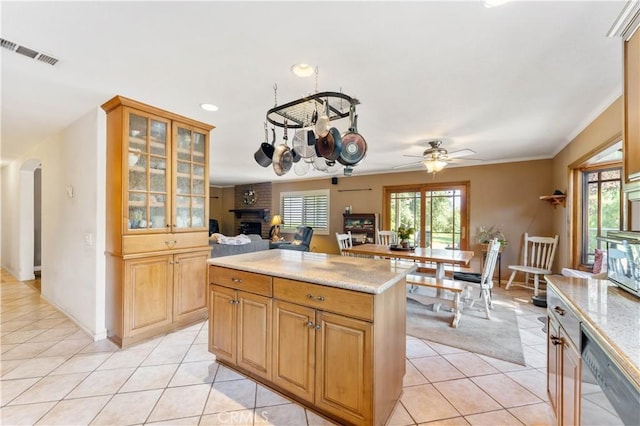 kitchen with arched walkways, glass insert cabinets, open floor plan, a fireplace, and light tile patterned flooring
