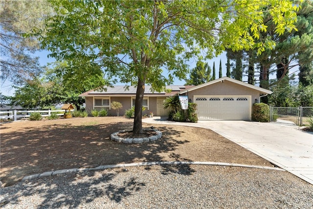 ranch-style house with a garage and solar panels