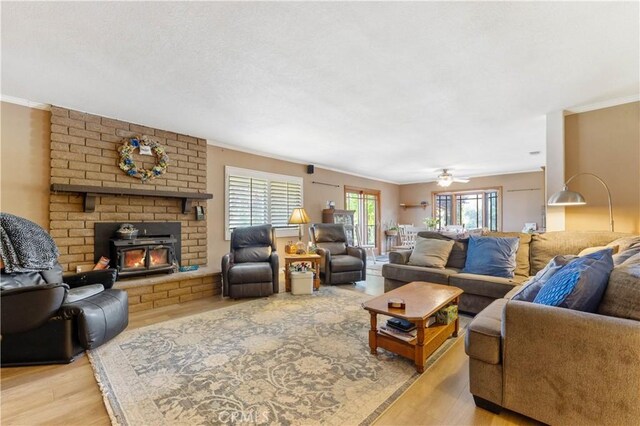 living room featuring light wood-type flooring, crown molding, and plenty of natural light