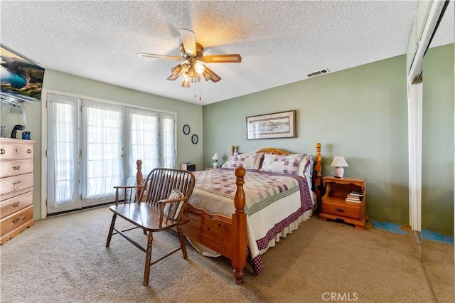 bedroom featuring a textured ceiling, ceiling fan, light carpet, visible vents, and access to outside