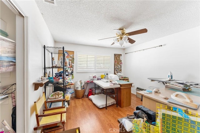 office area featuring ceiling fan, a textured ceiling, visible vents, and light wood-style floors