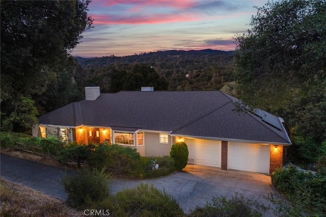 39309 Forest Park Ln, Oakhurst, CA 93644 - view of front of home with concrete driveway, a chimney, a forest view, and a garage