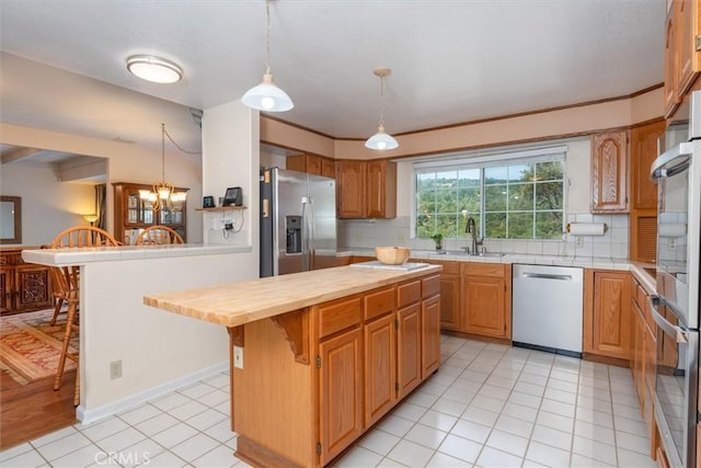 39309 Forest Park Ln, Oakhurst, CA 93644 - kitchen with a sink, stainless steel appliances, backsplash, and a breakfast bar area