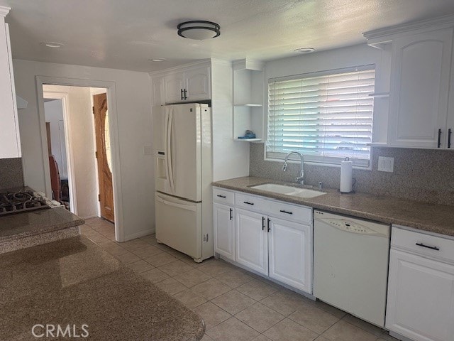 kitchen with sink, light tile patterned floors, white cabinetry, white appliances, and tasteful backsplash