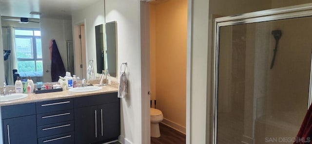 bathroom featuring hardwood / wood-style floors, vanity, toilet, and an enclosed shower