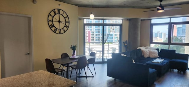 living room featuring ceiling fan and dark wood-type flooring