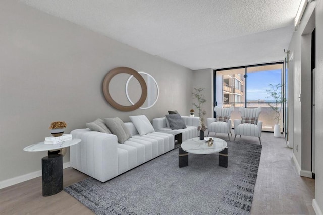 living room featuring a textured ceiling, floor to ceiling windows, and hardwood / wood-style flooring