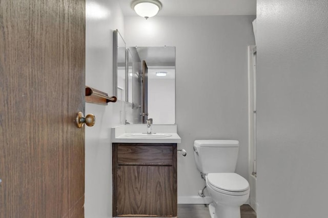 bathroom with a shower with shower door, toilet, and vanity