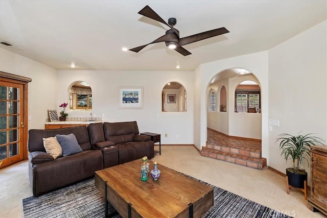 carpeted living room with ceiling fan