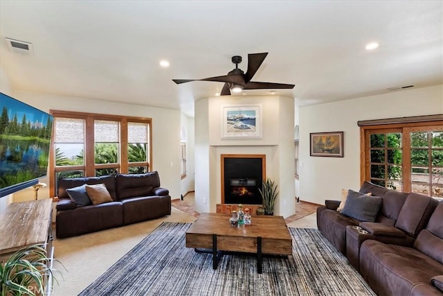 carpeted living room with ceiling fan and a healthy amount of sunlight