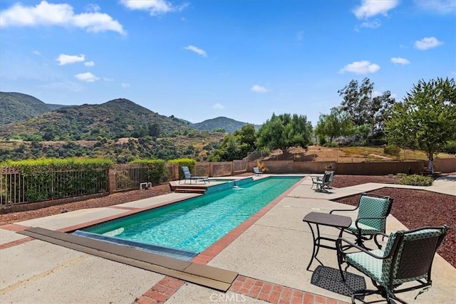 view of swimming pool with a mountain view and a patio