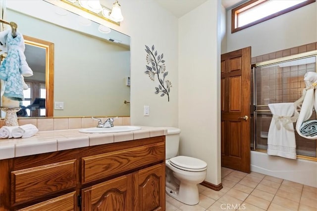 full bathroom featuring tile patterned floors, vanity, toilet, and enclosed tub / shower combo