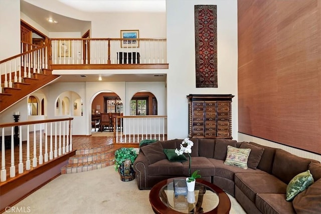 carpeted living room with a towering ceiling