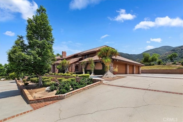 mediterranean / spanish-style house with a mountain view and a garage