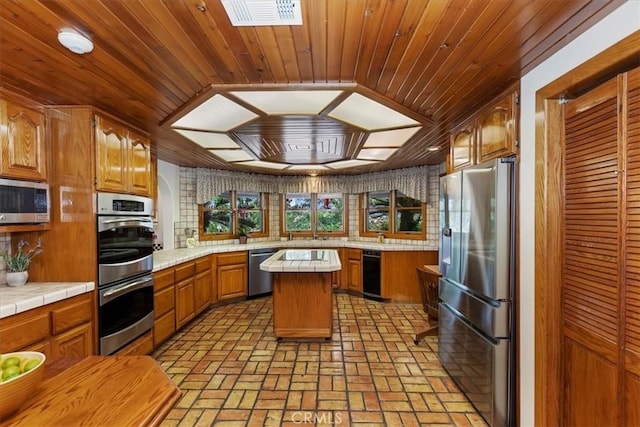 kitchen featuring decorative backsplash, a kitchen island, wooden ceiling, and stainless steel appliances