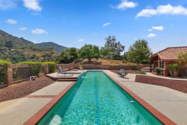 view of pool with a mountain view and a patio