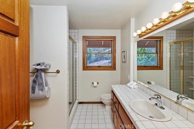 bathroom with tile patterned flooring, vanity, toilet, and a shower with shower door