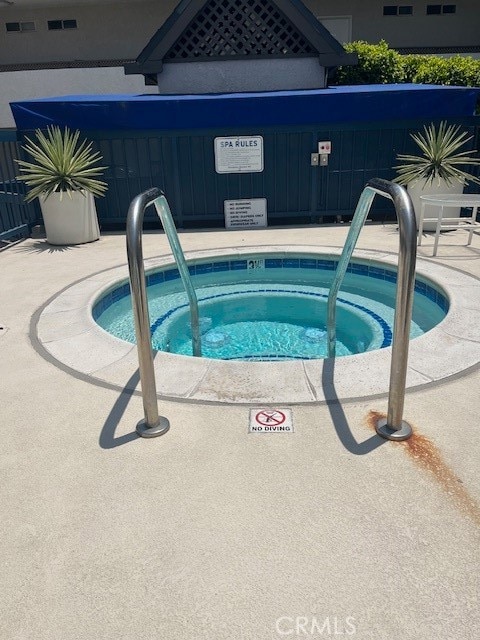 view of swimming pool featuring a patio and a community hot tub