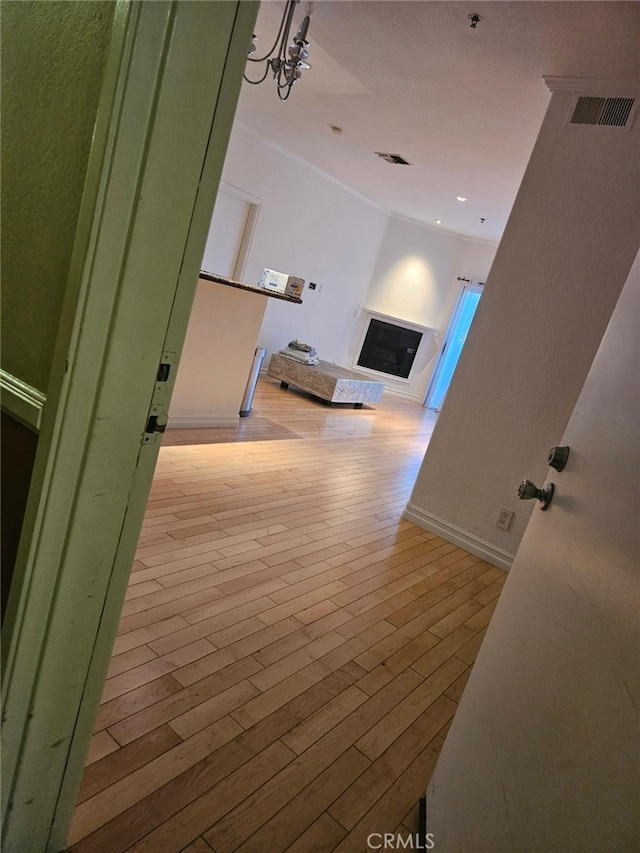 hallway featuring light hardwood / wood-style flooring and ornamental molding