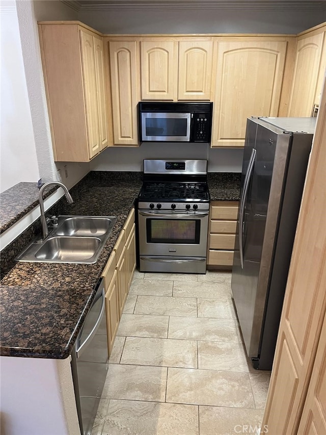 kitchen featuring light brown cabinetry, stainless steel appliances, sink, and dark stone countertops