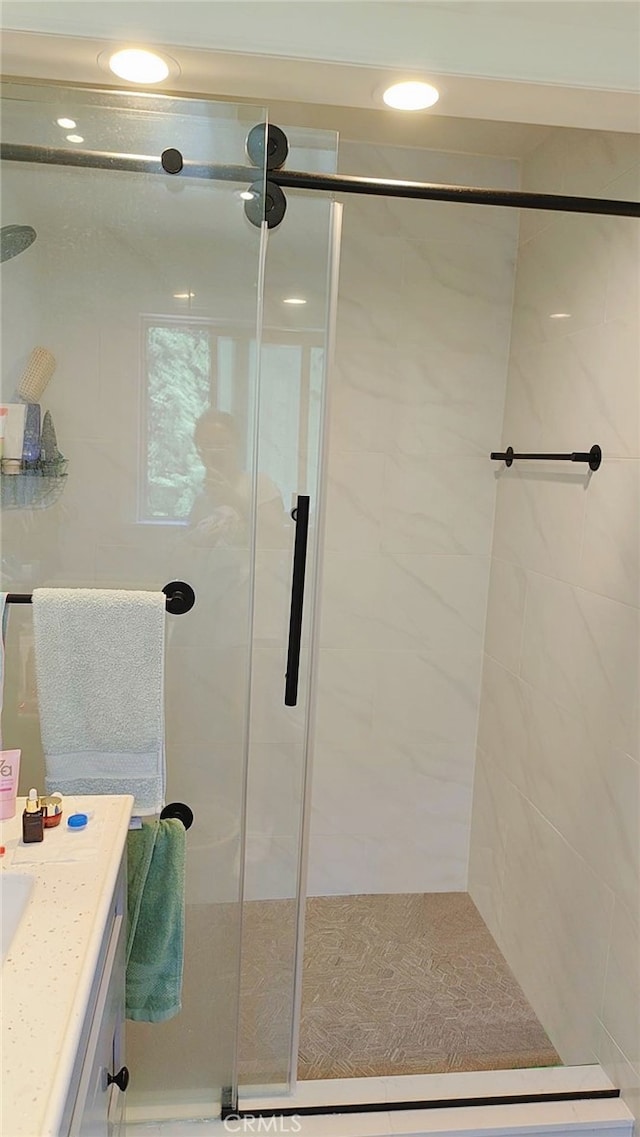 bathroom with vanity and a shower with shower door