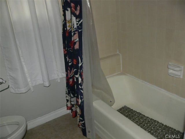 bathroom with shower / bath combo, tile patterned floors, and toilet