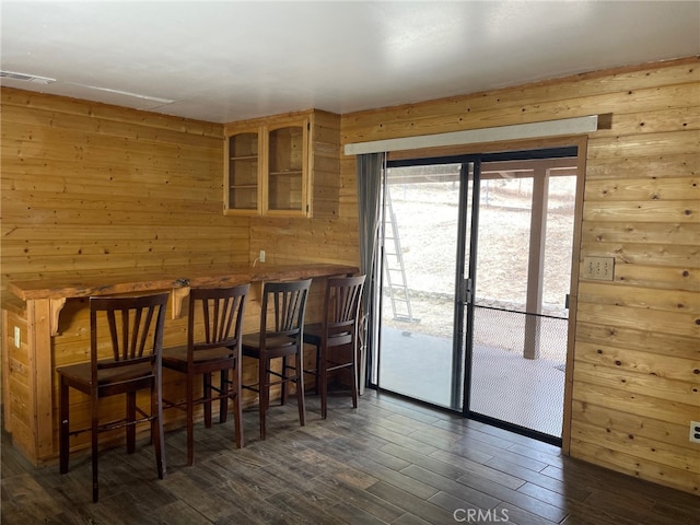 dining room with wooden walls and dark hardwood / wood-style flooring