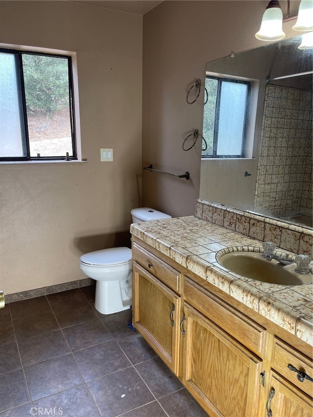 bathroom with vanity, toilet, a shower, and tile patterned flooring