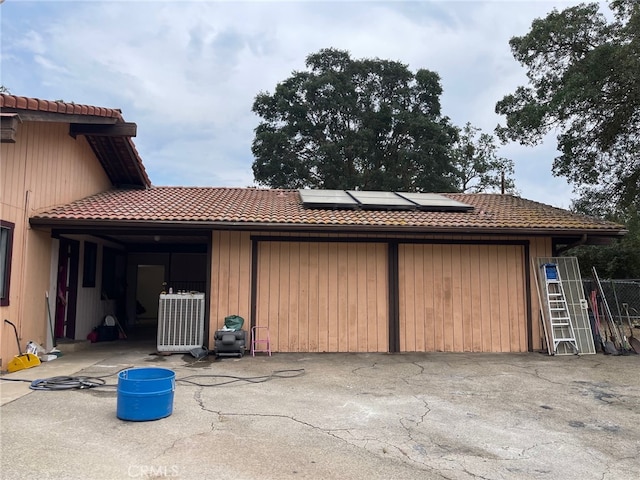 garage featuring solar panels and wooden walls