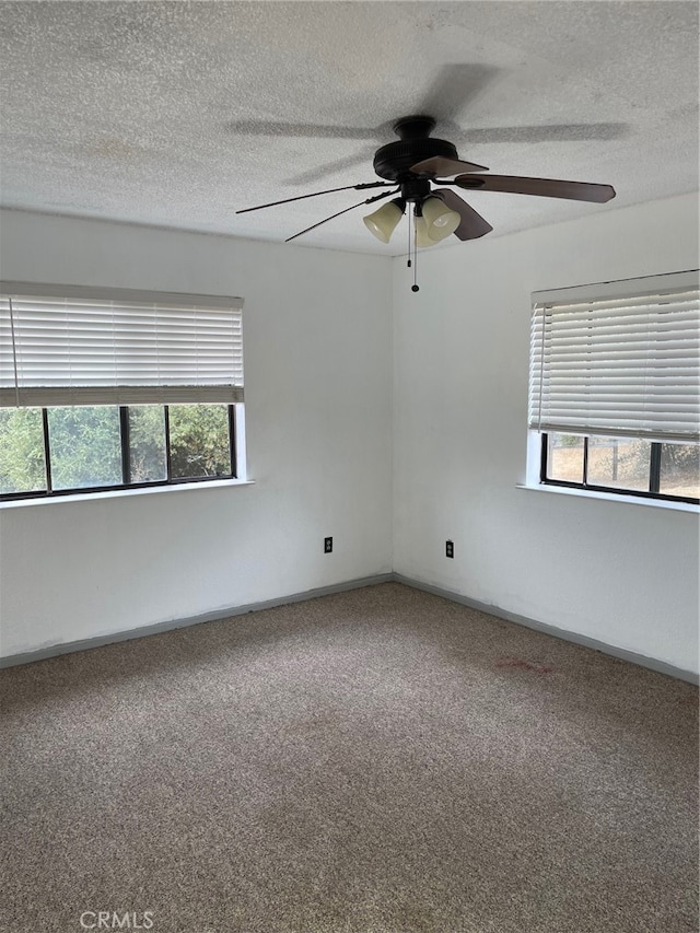 empty room featuring ceiling fan, a textured ceiling, and plenty of natural light