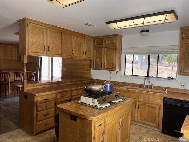 kitchen with black dishwasher, sink, plenty of natural light, and a kitchen island