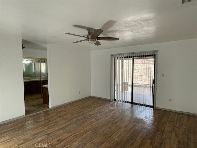 spare room with dark wood-type flooring and ceiling fan