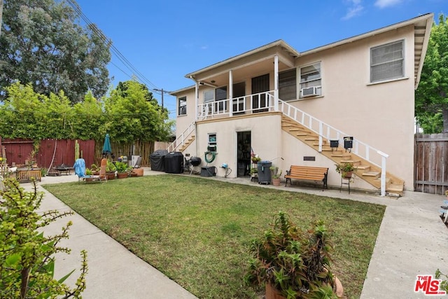 rear view of house with a patio area and a yard