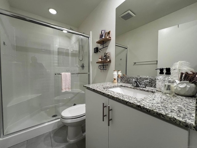 bathroom with toilet, tile patterned flooring, walk in shower, and vanity