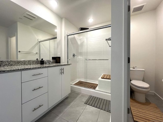 bathroom with toilet, vanity, an enclosed shower, and tile patterned flooring