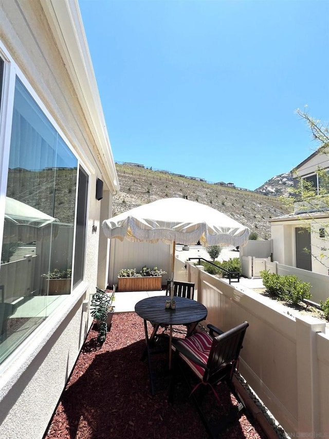 view of patio with a mountain view and a balcony